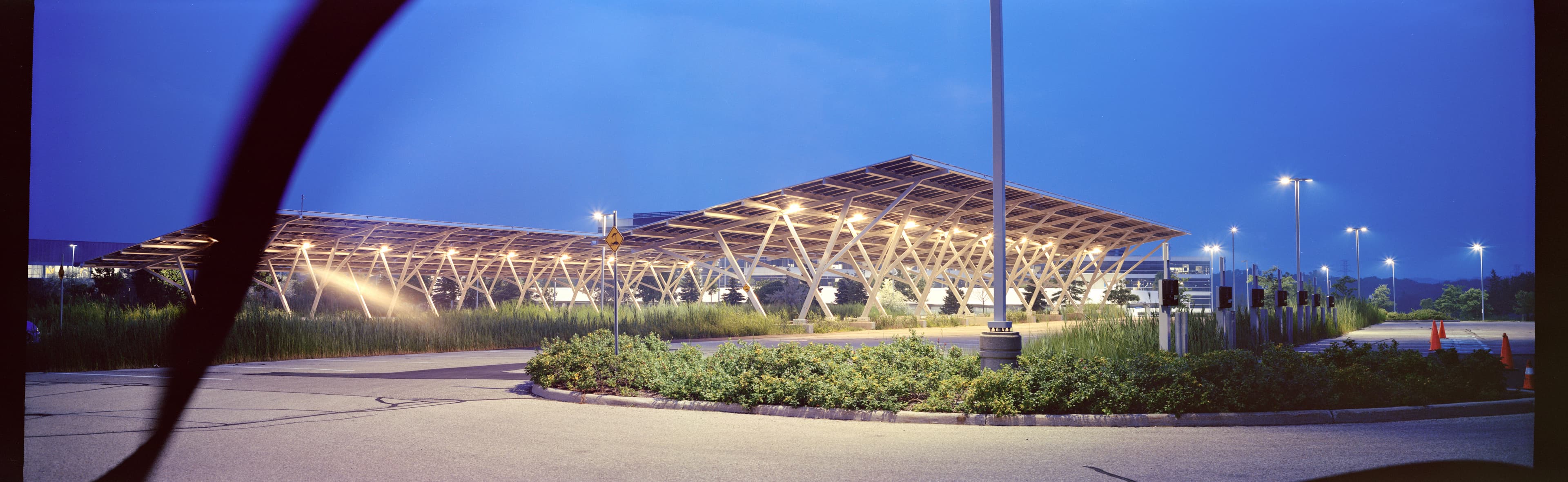 A solar panel covered parking lot at dusk